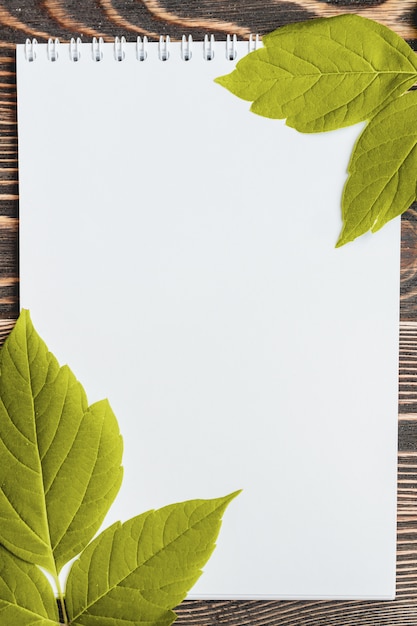 Folha de outono com uma folha em branco na mesa de madeira