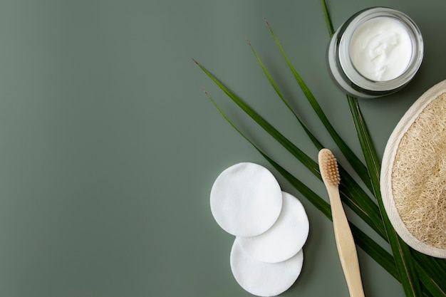 Foto folha de palmeira com escova de dente de madeira e creme