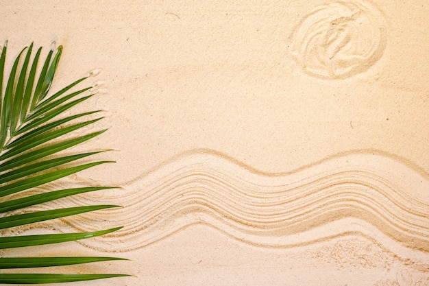 Folha de palmeira na areia com fundo padrão de verão