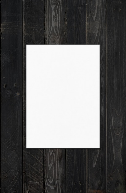 Folha de papel A4 em branco isolada em superfície de madeira preta