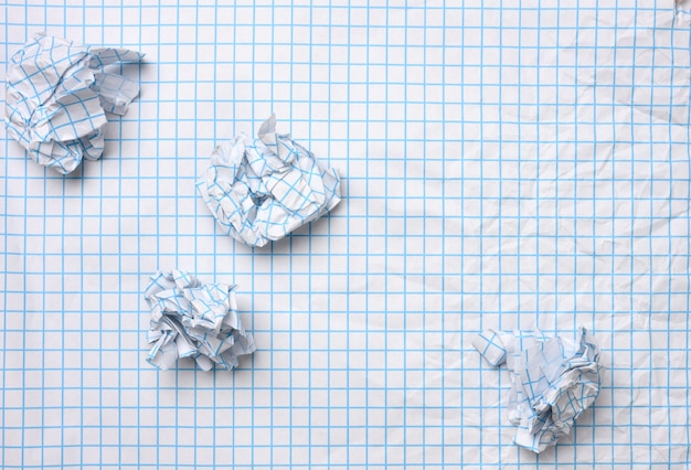 Folha de papel amassada em branco em uma gaiola e bolas amassadas, vista de cima