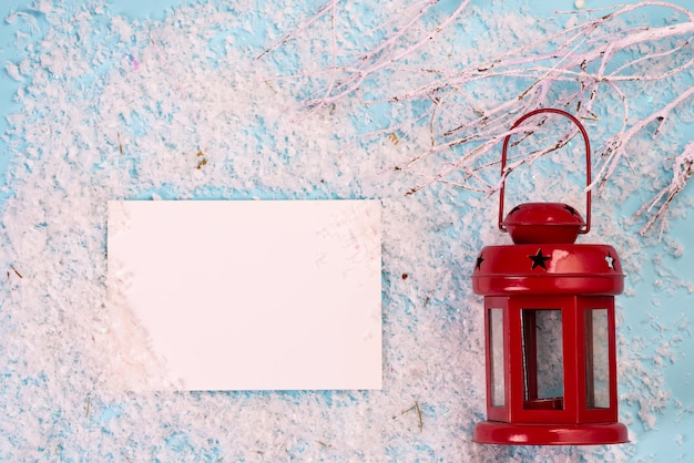 Folha de papel branco e lanterna vermelha de Natal na neve