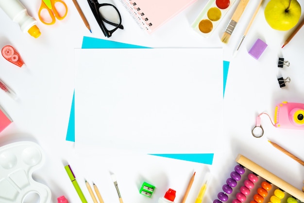 folha de papel em branco com acessórios escolares. Postura plana. Copie o espaço
