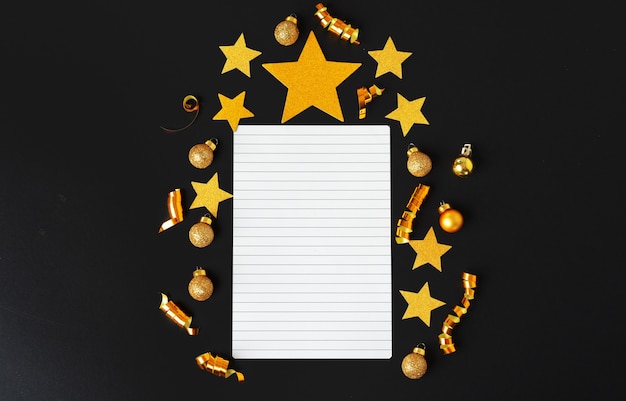 Folha de papel em branco com estrelas decorativas douradas. Conceito de resoluções de ano novo