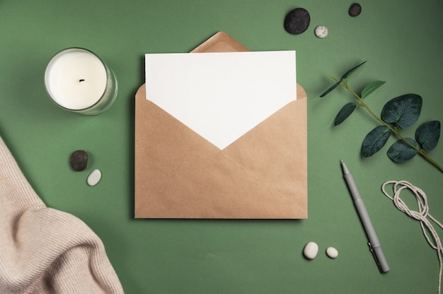 Folha de papel em branco com um envelope na superfície verde