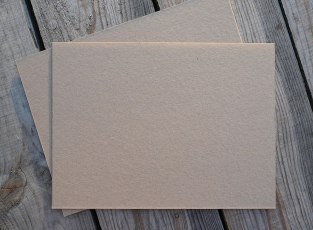 Folha de papel kraft em branco sobre fundo de madeira Pedaço de papel ou papelão em branco sobre uma mesa