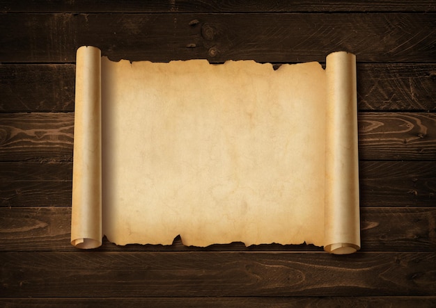 Folha de papel medieval velha. Rolo de pergaminho horizontal em um fundo de placa de madeira