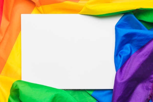 Folha de papel vazio branco na bandeira LGBT amassada