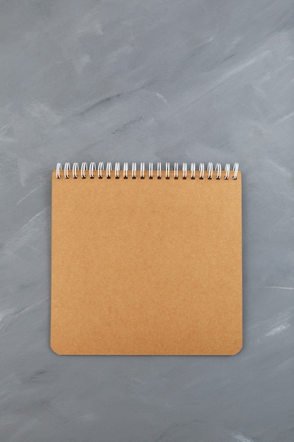 Folha de papelão de caderno espiral marrom em branco em cinza