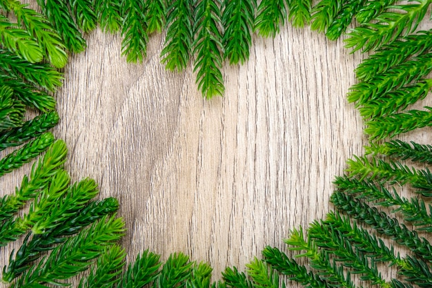 Foto folha de pinheiro em forma de coração verde em madeira clara para fundo e textura use para decoração para publicidade on-line e conceito de natal feliz