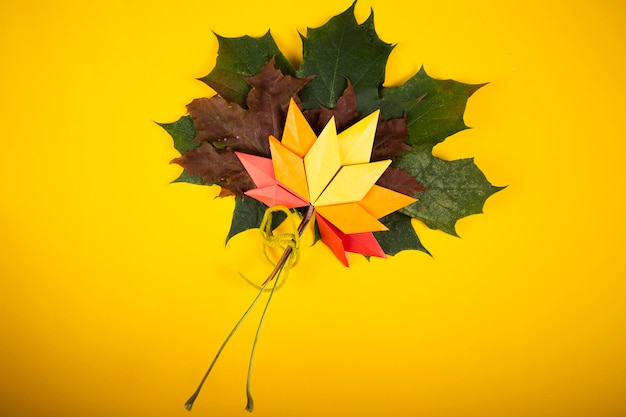 Folhas caídas conceito outono tradicional papel ofício arte origami topshot em fundo amarelo papercraft