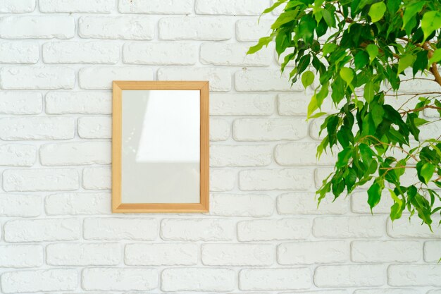 Folhas da planta da casa contra a parede de tijolos brancos com espaço de cópia