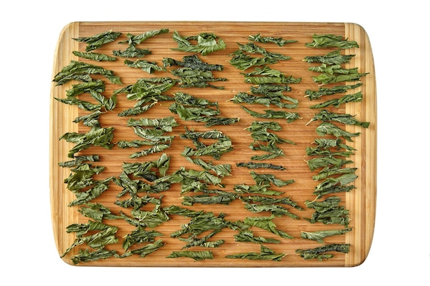 Folhas de chá de uva de groselha fermentadas torcidas são secas em uma tábua de madeira