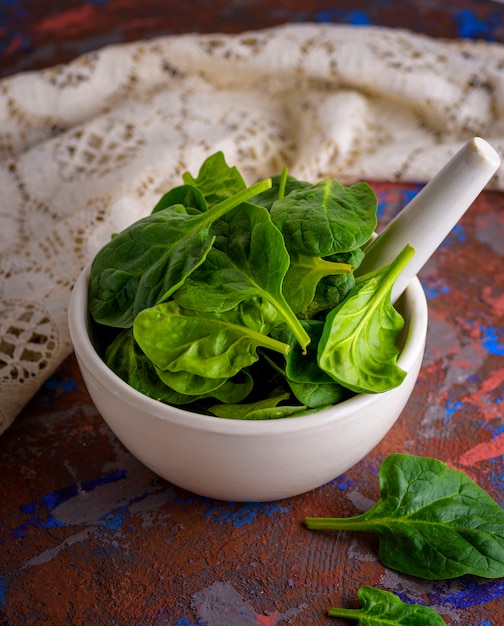 Folhas de espinafre verde fresco em um almofariz de cerâmica branca