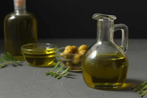 Foto folhas verdes de azeite e azeitonas na mesa