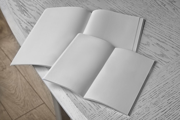 Folletos en blanco abiertos en una mesa de madera