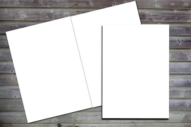 Foto folletos en blanco de maqueta blanca abierta y cerrada sobre fondo de escritorio de tablones de madera en la vista superior concepto de diseño de maqueta