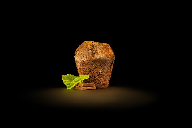 Fondant de chocolate con trozos de chocolate y hojas de menta, espolvoreado con cacao