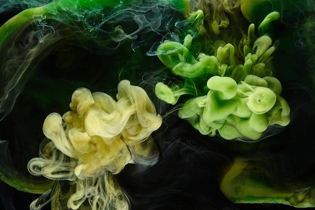 Foto fondo abstracto de arte fluido líquido pinturas acrílicas de baile verde bajo el agua océano de humo cósmico