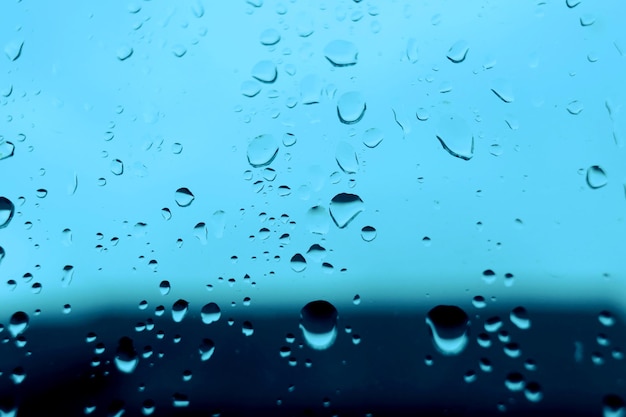 Fondo abstracto azul con gotas de agua en el cristal