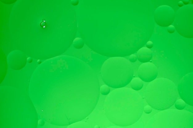 Fondo abstracto con círculos de aceite verde en el agua