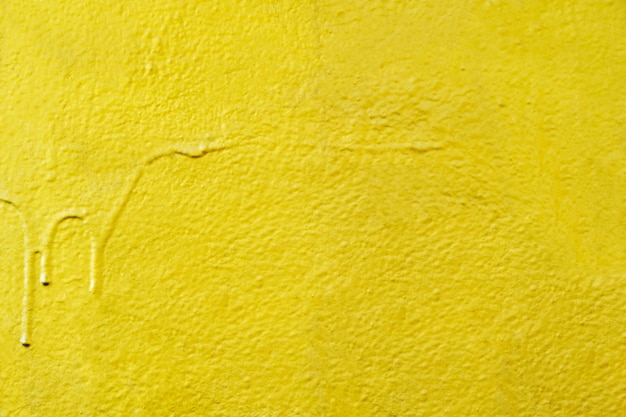 Fondo abstracto de color amarillo pintado en muro de hormigón.