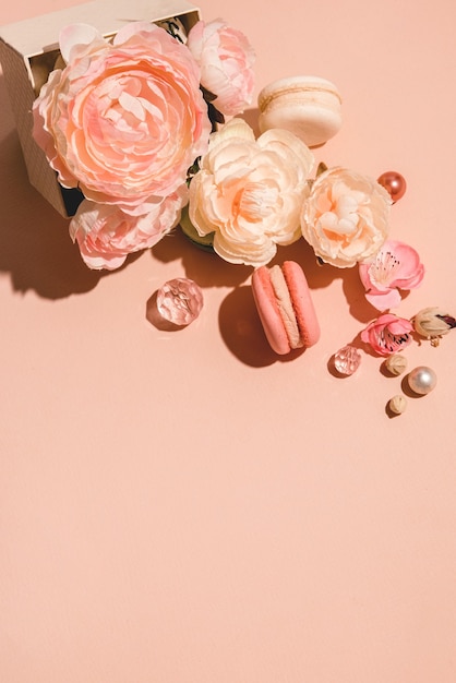 Fondo abstracto con flores y una caja de regalo en tonos apagados. Moderno concepto minimalista monocromo de melocotón pastel
