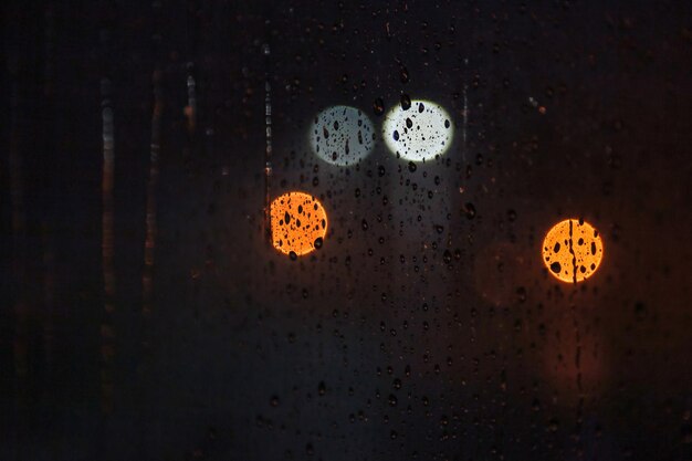 Foto fondo abstracto con gotas de lluvia en la ventana y luz borrosa nocturna