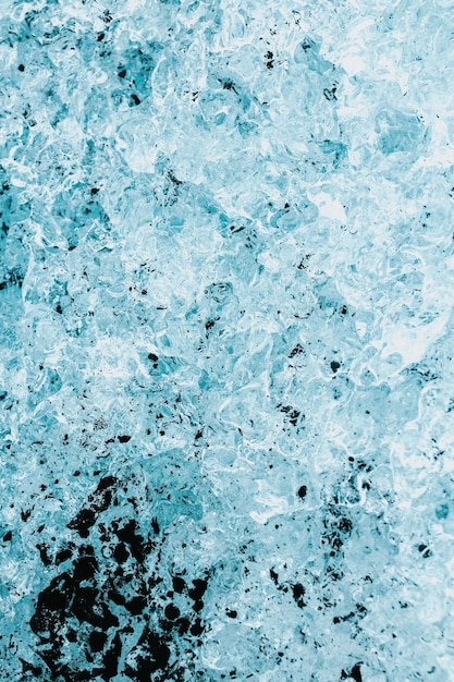 Fondo abstracto de hielo azul de Islandia con negro volcánico Fondo azul con grietas en la superficie del hielo Bloques de hielo de la laguna glaciar de Jokulsarlon Parque Nacional Vatnajokull y playa negra