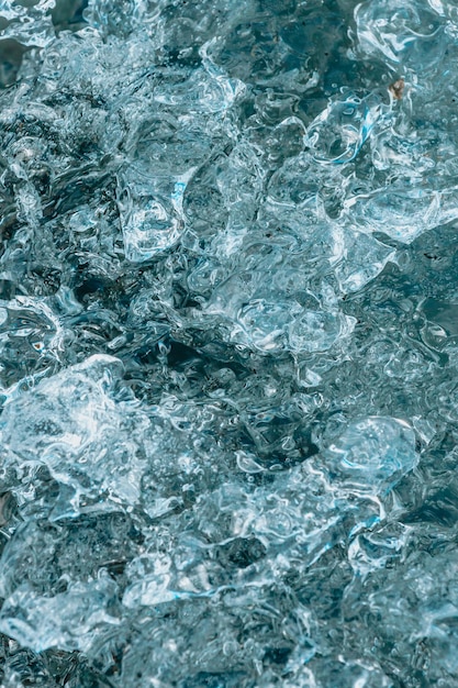 Fondo abstracto de hielo azul de Islandia con negro volcánico Fondo azul con grietas en la superficie del hielo Bloques de hielo de la laguna glaciar de Jokulsarlon Parque Nacional Vatnajokull y playa negra