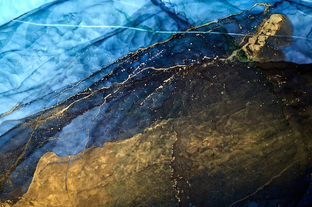 Fondo abstracto de lujo en técnica de tinta de alcohol, pintura líquida de oro azul índigo, manchas acrílicas dispersas y manchas arremolinadas, materiales impresos