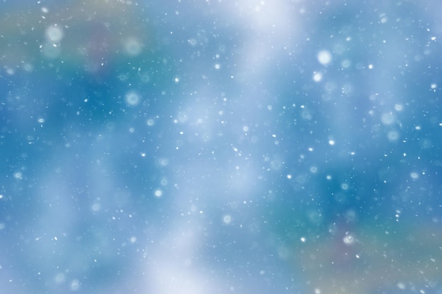 Fondo abstracto de nieve / invierno borrosa, copos de nieve sobre fondo de hoja resplandeciente borrosa abstracta