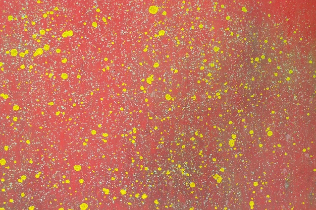 Fondo abstracto rojo con gotas amarillas. Hoja de metal pintado de rojo con liquen amarillo_