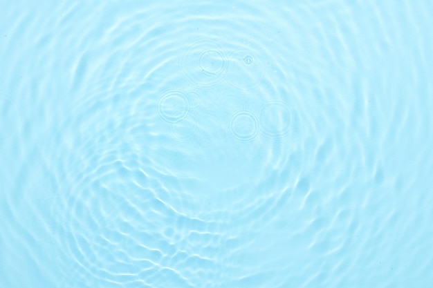 Fondo abstracto de la superficie azul del agua Olas y ondas de crema hidratante cosmética con burbujas