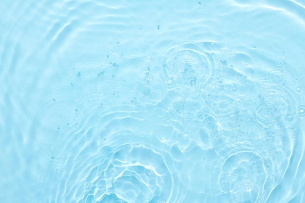 Fondo abstracto de la superficie azul del agua Olas y ondas de crema hidratante cosmética con burbujas