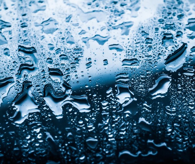 Foto fondo abstracto de textura de agua gotas de agua sobre vidrio azul como elemento macro científico clima lluvioso y fondo de arte de superficie natural para el diseño de marca ambiental