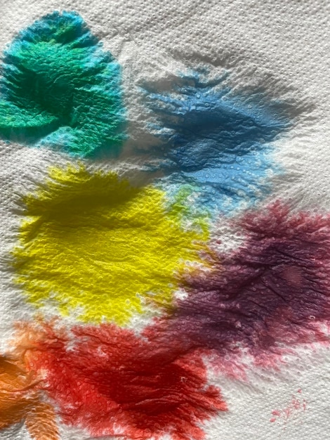 Fondo acrílico pintado a mano abstracto una mancha de diferentes colores en una servilleta blanca