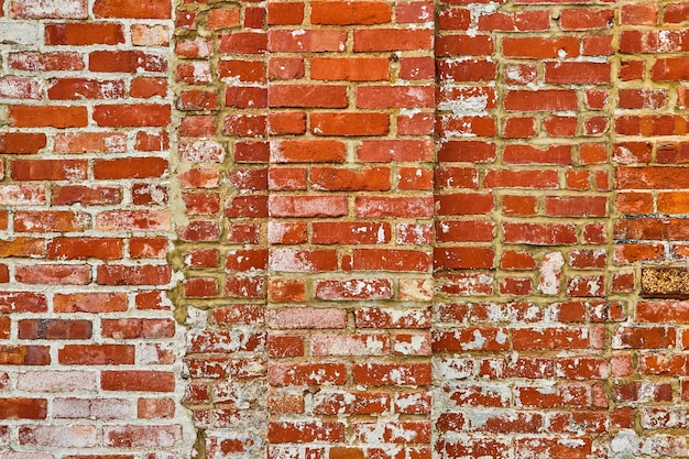 Fondo activo en descomposición y capas de pared de ladrillo rojo con manchas de pintura blanca