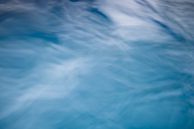 El fondo de agua azul natural suave con el extracto de bokeh en el mar