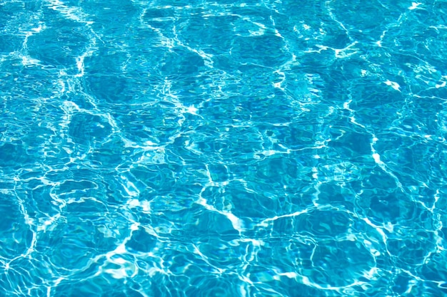 Fondo de agua azul en la piscina con reflejo del sol onda de agua ondulada en la piscina Fondo de agua clara