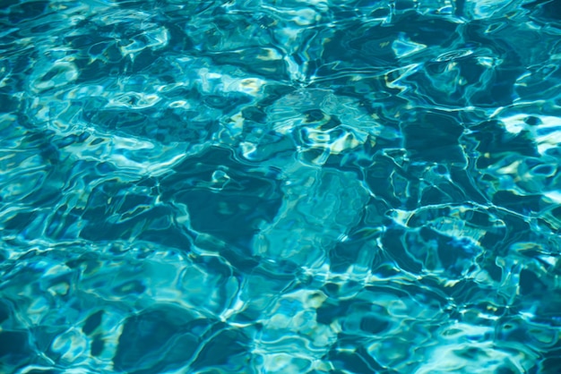 Fondo de agua ondas ondas azul piscina patrón agua de la superficie del mar en la piscina con sol