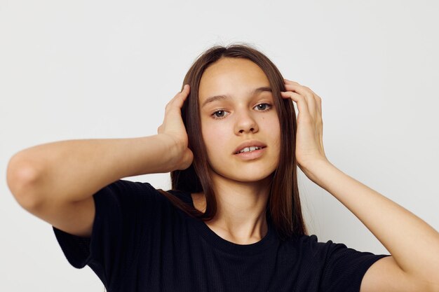 Fondo aislado de la emoción de la camiseta negra del pelo largo de la mujer hermosa joven