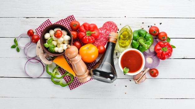 Fondo de alimentos Champiñones queso salchichas tomates verduras Vista superior Sobre un fondo de madera Espacio de copia libre