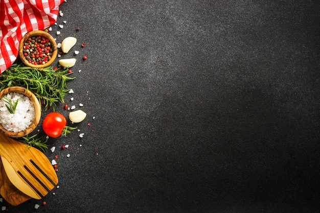 Foto fondo de alimentos en negro hierbas especias y utensilios vista superior con espacio para texto