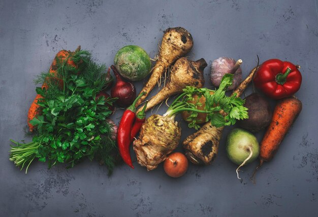 Fondo de alimentos de otoño con cultivos de raíces de verduras apio rábano chirivías zanahorias pimienta en la mesa de la cocina Cosecha mercado agrícola local compras concepto de alimentación saludable Banner de vista superior