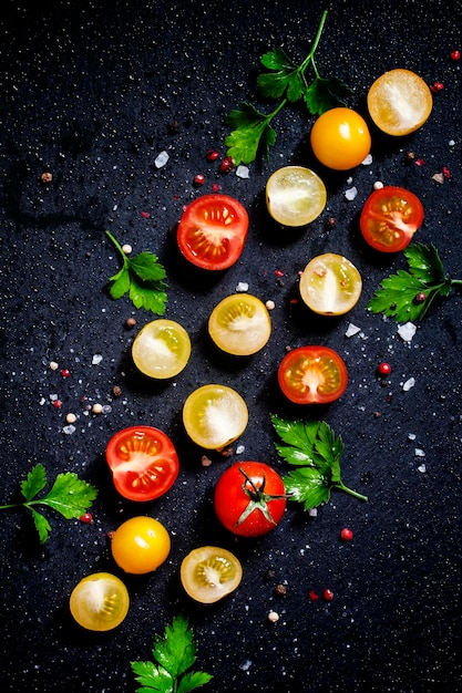 Fondo de alimentos rojo amarillo y naranja tomates cherry fondo negro vista superior