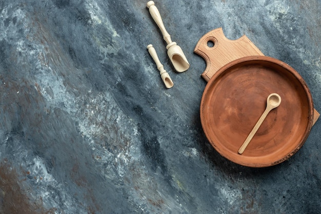 Fondo de alimentos. utensilios de cocina plato vacío y tabla de cortar de madera. banner, menú, lugar de recetas para texto, vista superior.