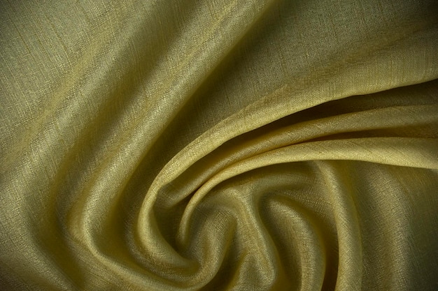 Un fondo amarillo abstracto en tela de lujo y tela onda o fondo de textura de seda ondulada y fondo de material de terciopelo satinado o diseño elegante de papel tapiz