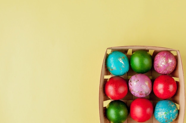 Fondo amarillo de huevos de Pascua feliz. Huevos decorados con brillo dorado en la canasta, para tarjetas de felicitación, promoción, póster. Copie el espacio.