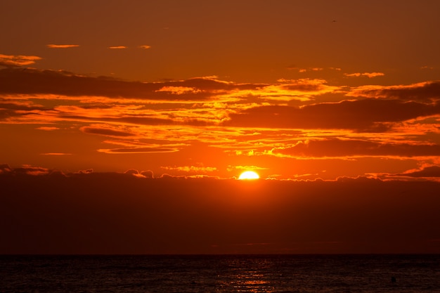 Fondo anaranjado del cielo de la puesta del sol en la tarde